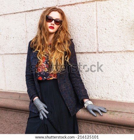 Close up portrait of beautiful ginger woman with perfect long fluffy hairs, wearing stylish elegant clothes. Autumn retro style. Pink urban background.