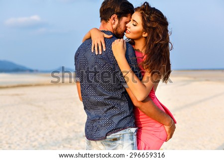 Amazing summer portrait of sensual couple hugs on lonely exotic beach. Romantic weekend, stylish clothes.