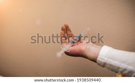 Syringe in a hand of a little girl. Vaccine vaccination child baby doctor injection pediatrician injecting arm health immunization hand hospital needle syringe. Covid 19 Coronavirus vaccine concept.