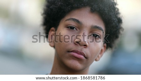 Serious mixed race young boy looking at camera. Black ethnic kid portrait