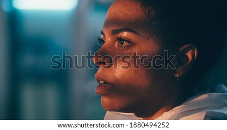 Exhausted ethnic female doctor taking off protective goggles and mask then touching sweaty face and breathing heavily during work in hospital