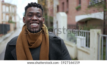 Black man celebrating success raising fist in the air. Successful African guy walking in city