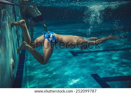 Swimmer in swimming pool.Underwater image.Grain effect added for artistic impression.