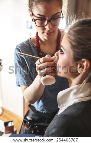 Make-up artist work on her friend.Real people.