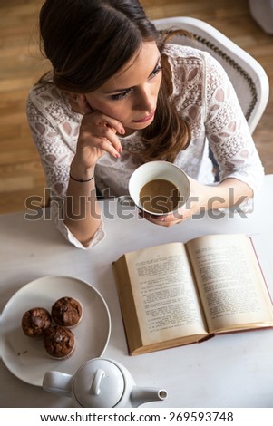 Beautiful middle age woman drink coffee at home.Serious face,Loneliness.Blur and grain added for artistic impression.