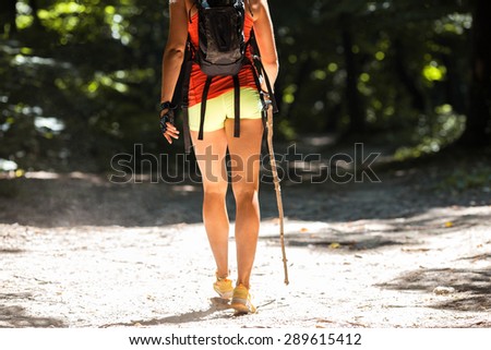 Female hiker hiking trough forest.Legs.Rear view.