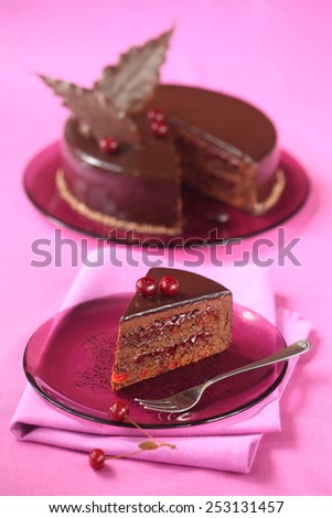 Piece of Chocolate Cherry Mousse Cake on a purple plate, napkin and bright purple background.