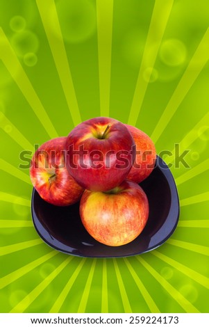 Four ripe red apple on a black plate