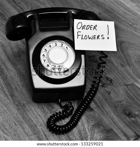 Retro telephone with reminder note to order flowers