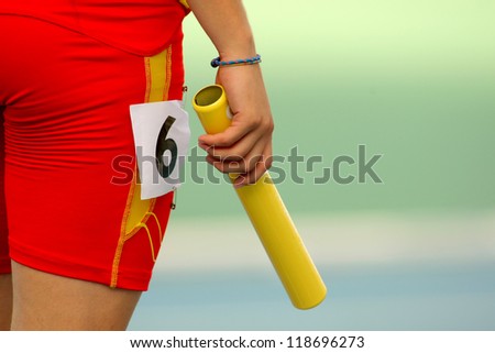 Athlete with a baton waiting for a relay event
