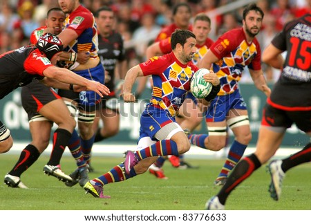 BARCELONA - APRIL 9: Julien Candelon of Perpignan drives the ball during the European Cup quarter-final match USAP Perpignan vs RC Toulon at the Olympic Stadium on April 9, 2011 in Barcelona, Spain