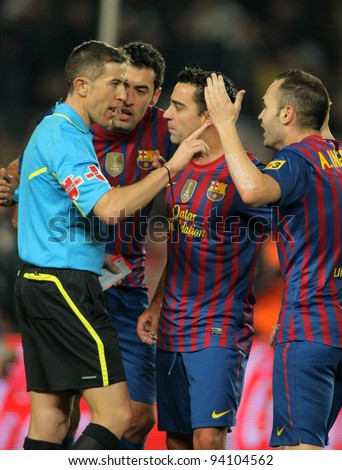 BARCELONA - JAN, 15: FC Barcelona players talk with the referee Iglesias Villanueva during the Spanish league match against R Betis at the Camp Nou stadium on January 15, 2012 in Barcelona, Spain