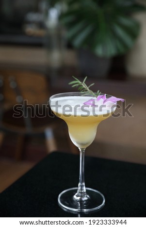 Yellow Cocktail glass with ice at a bar counter