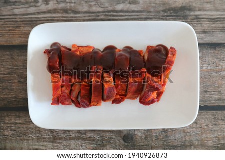 Roasted pork thai local food with red sauce on wood background