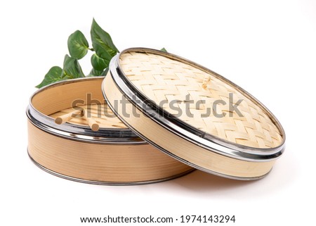 An elegant metal edged Asian or Chinese bamboo vegetable and dumpling steamer with chopsticks isolated on white