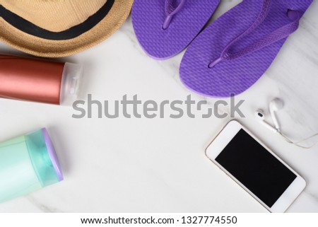 Close-up of a smartphone, flip flops, sunscreen and a hat. Travel concept. Stok fotoğraf © 