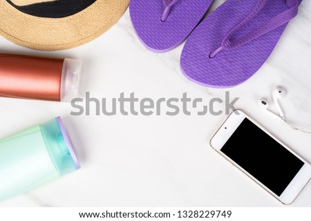 Close-up of a smartphone, flip flops, sunscreen and a hat. Travel concept. Stok fotoğraf © 