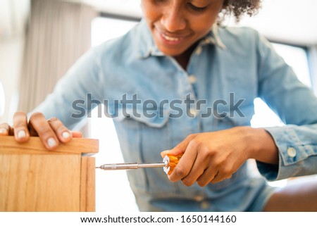 Similar – Image, Stock Photo Afro woman repairing furniture at home.