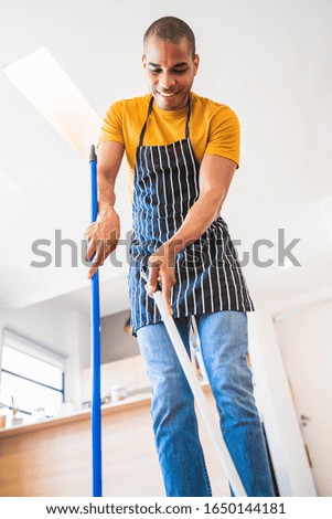 Similar – Foto Bild Lateinamerikanischer Mann kehrt zu Hause den Holzboden mit Besen.