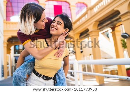 Portrait of lovely lesbian couple spending time together and having fun at the street