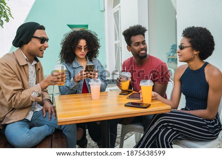 Afro friends having fun together while drinking fruit juice.