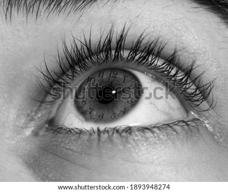 A grayscale closeup shot of a human open eye looking to the top