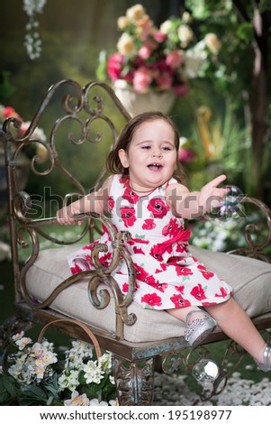 Little girl in summer garden. Outdoor. Beauty, healthy. Playing with soap bubble