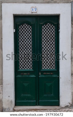 Green door in the wall of the house