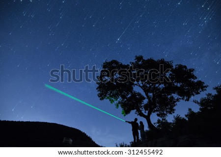 silhouette couple  under  a tree and enjoying starry sky in nights cape