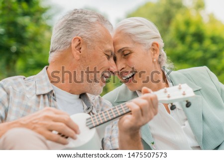 Similar – Image, Stock Photo Cheerful man playing ukulele guitar