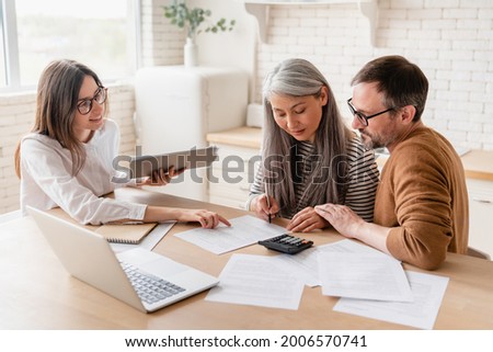 Insurance agent consulting mature family couple, discussing health insurance, signing contract deal of loan pension mortgage at home, calculating funds, investments, savings