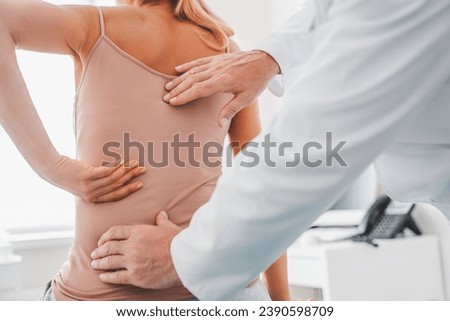 Foto Bild Orthopäde massiert den Rücken eines gesichtslosen männlichen Patienten mit Ellbogen