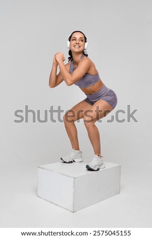 Similar – Image, Stock Photo Focused sportswoman doing squats with elastic band in apartment