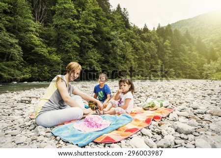 Family picnic by the river. Rapids and the forest in the background
