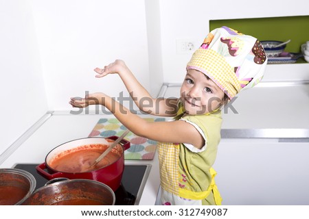 Little girl cooking tomato sauce. Preparing stores for the winter.