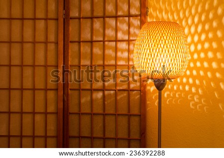 decorative lamp in front of a wooden screen