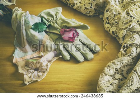 poetic composition with a rose lying on an elegant glove between a veil and a table cloth