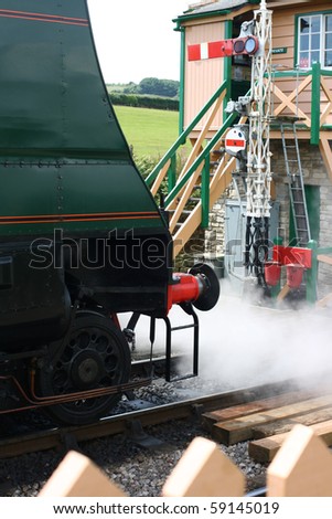 The front end of a period steam engine, letting off steam at the end of the platform at Harmans Cross station.