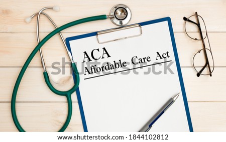 Paper with ACA Affordable Care Act on the office table, calculator and stethoscope. Medical concept. Imagine de stoc © 