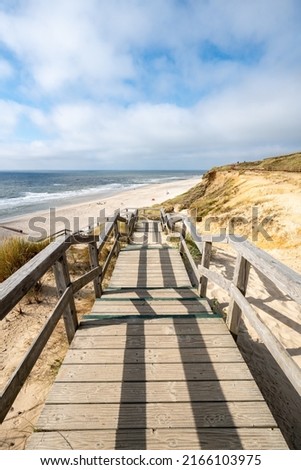 Foto Bild Rotes Kliff an der Küste der Insel Sylt bei Sonnenuntergang.  Leere Strandkulisse an der Nordsee