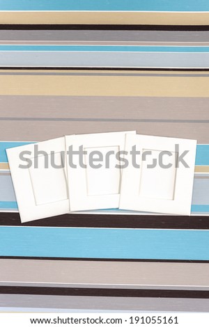 Blank photographs frames over colorful striped background