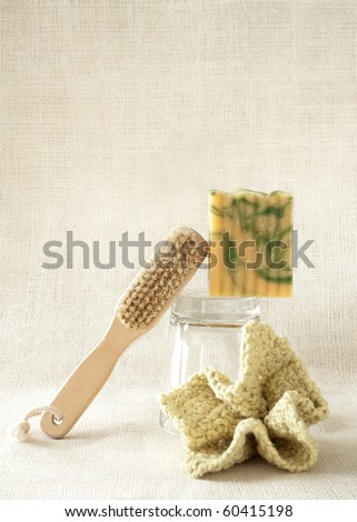 A bar of soap and scrub brush with a wash rag