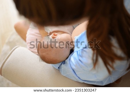 Foto Bild Anonyme Mutter, die ein Baby mit einem Lätzchen füttert