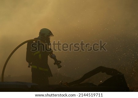 Similar – Foto Bild Silhouette eines Feuerwehrmannes, der vor den Blicken einer Menschenmenge kämpft, um ein tobendes Feuer einzudämmen