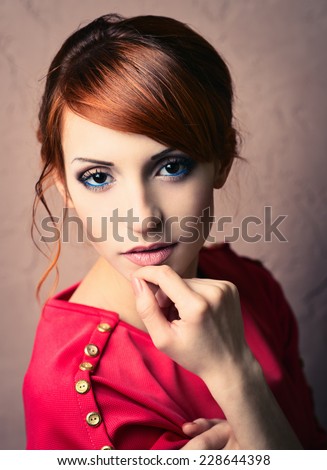 Beautiful young fashionable woman posing in red dress, smiling, looking at camera. Vogue Style