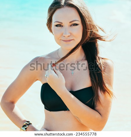 Woman with beautiful body on a tropical beach. beautiful young woman in a black bathing suit relaxing on the beach. Hipster style. Photo with instagram style filters