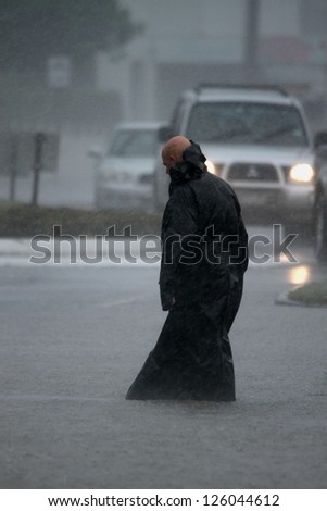 BRISBANE, AUSTRALIA - JANUARY 27 : Unidentified man braves the elements during ex tropical cyclone Oswald on January 27, 2013 in Brisbane, Australia