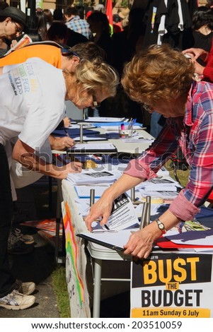 BRISBANE, AUSTRALIA - JULY 06 : Unidentified  older Australians signing budget petition at Bust The Budget anti liberal governement Rally July 06, 2014 in Brisbane, Australia