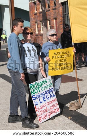 BRISBANE, AUSTRALIA - JULY 12 : Unidentified protesters with anti refugee policy signs outside Liberal National Party national conference July 12, 2014 in Brisbane, Australia