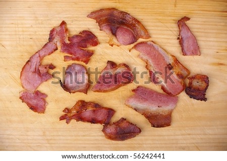 cooked bacon bits on wooden chopping  board